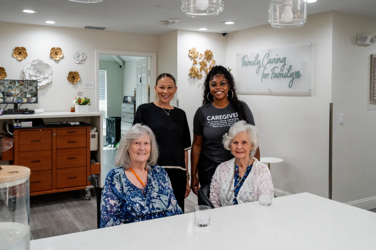 Four people smiling together around the kitchen island